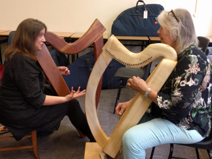 Two women with harps talking